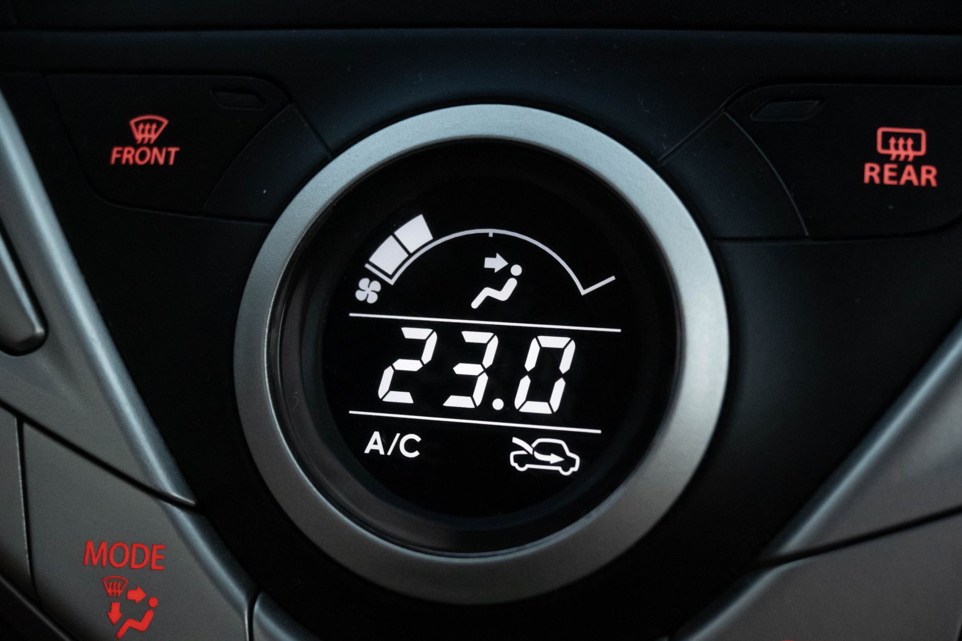 Close-up of an automatic gear selector and dashboard controls