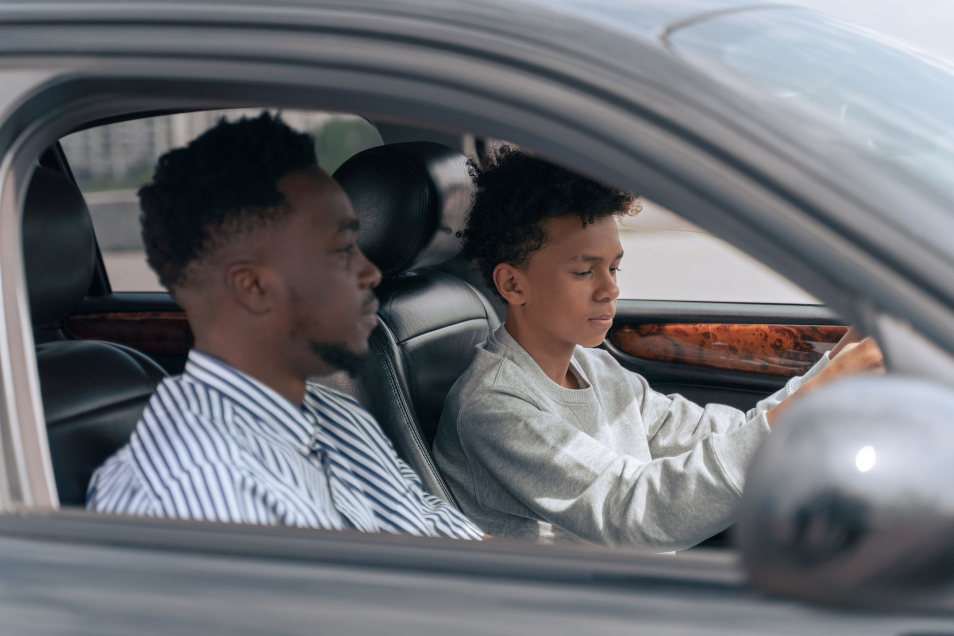 A driving instructor beside a learner at the wheel of a car