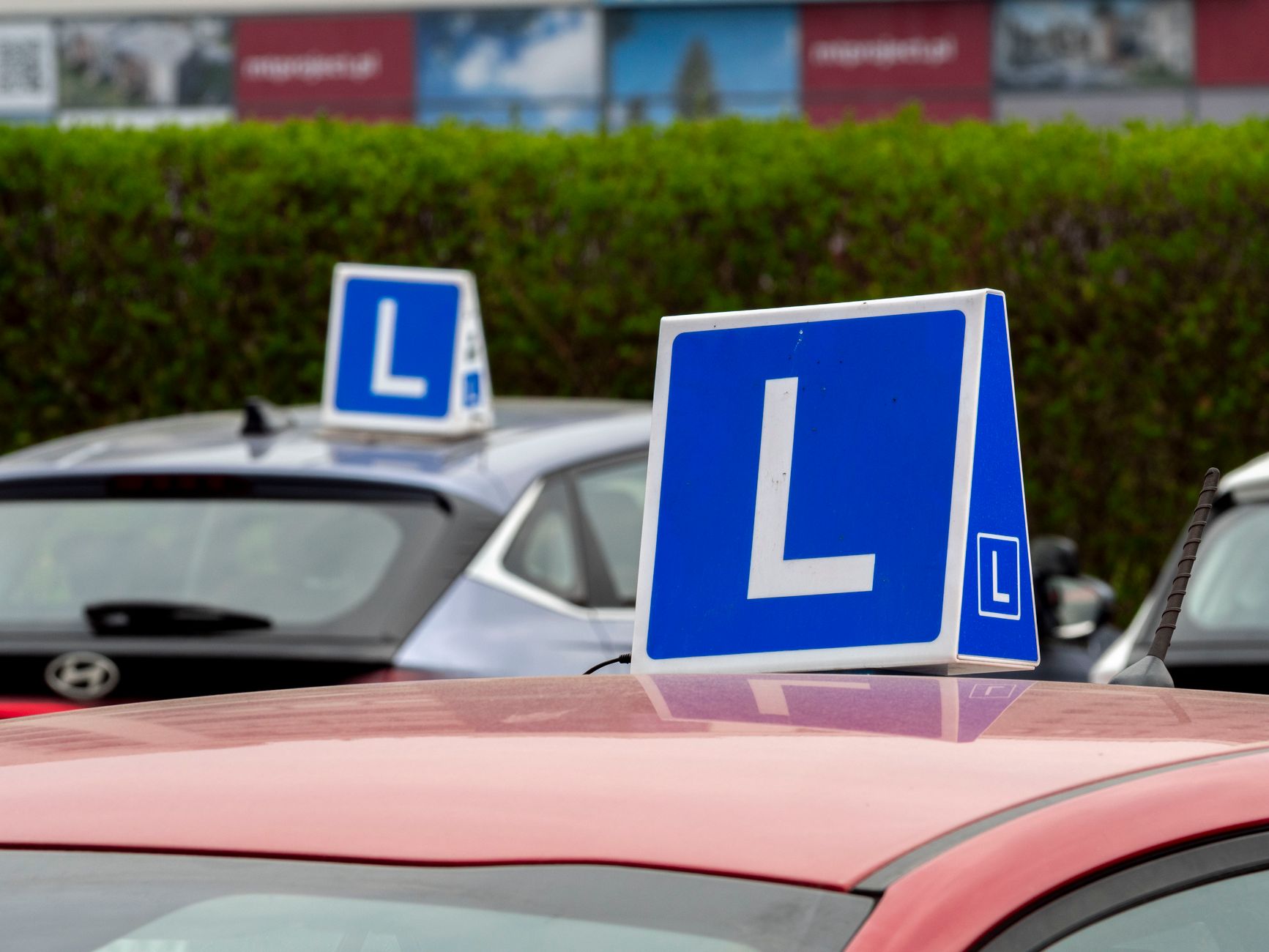 A learner driver car with an L-plate on a city road